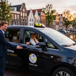 Taxi Amsterdam service showcasing a professional driver picking up passengers in a branded vehicle amidst the city's iconic canals.